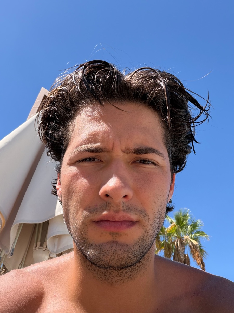 Close-up of Braiden under a bright blue sky by the beach